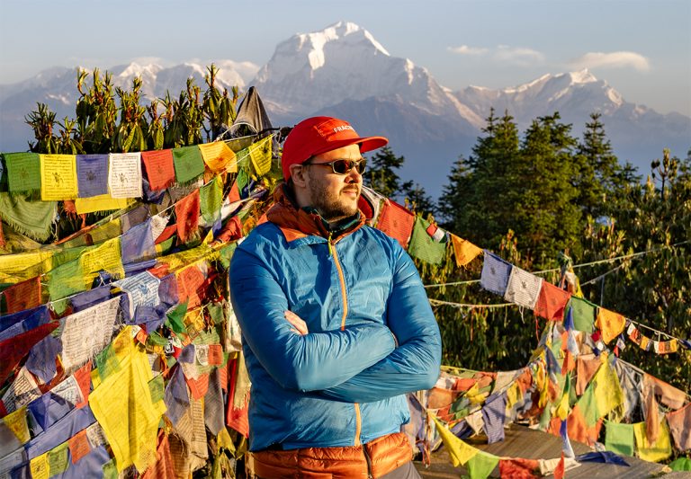 Philip in the Himalayas, in front of prayer flags
